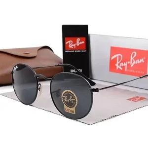 Round sunglasses with dark lenses resting on a brown case, a display card behind them